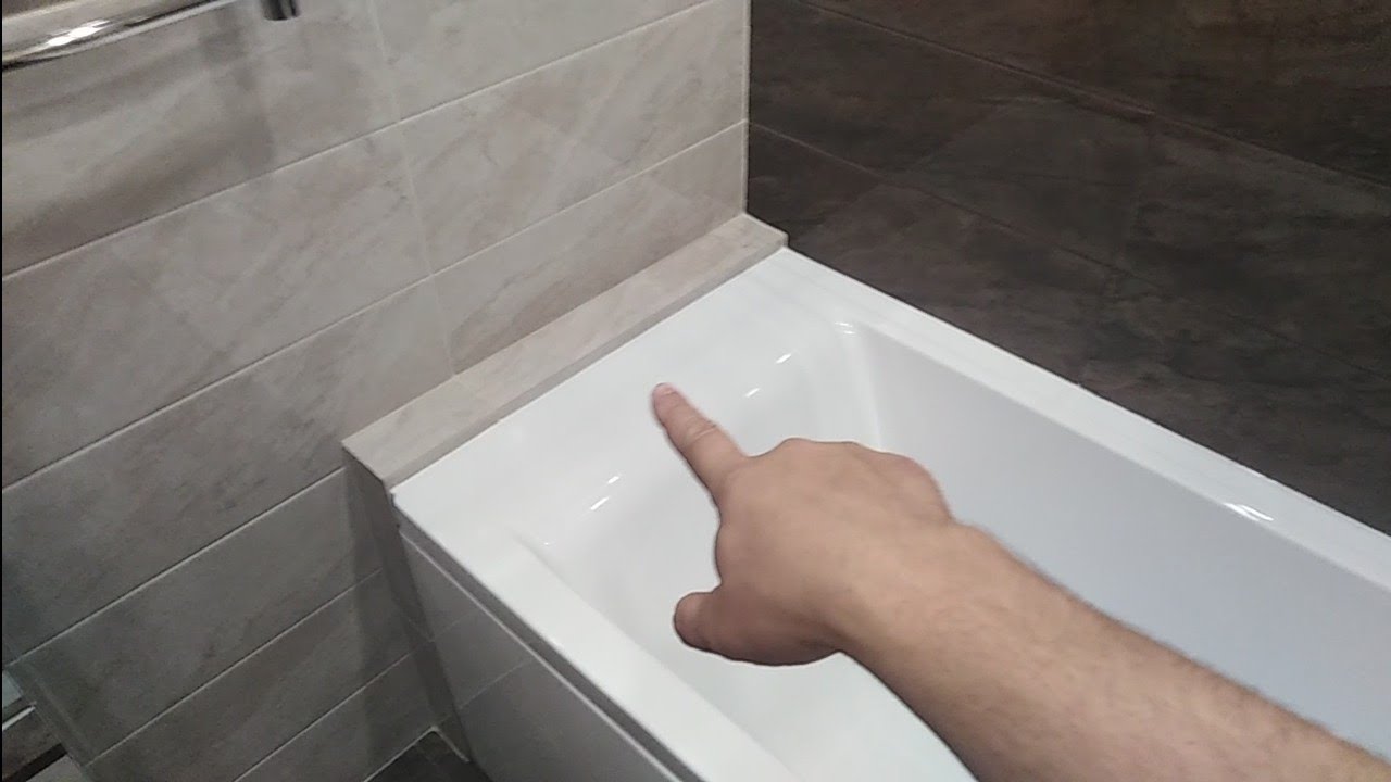 Как сделать между ванной и стеной. Галтель для ванны заделать щель 80 мм. Примыкание плитки к ванной. Примыкание ванны к плитке. Шов между ванной и стеной.